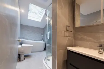 a bathroom with a tub and a toilet and a sink at Bright Beautiful Modern 2 Bed Home Pass The Keys in Cambridge