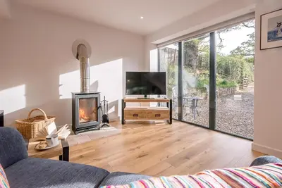 a living room with a fireplace and a television at Little Honey Pot, Benhall in Saxmundham