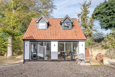 a small cottage with an orange roof and windows at Little Honey Pot, Benhall in Saxmundham