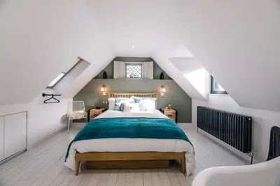 a bedroom with a large bed in a attic at Little Honey Pot, Benhall in Saxmundham