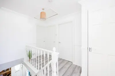 a white staircase in a white home with white walls at 6 Bedroom Larger group House with Parking Corringham Stanford Le Hope in Horndon on the Hill