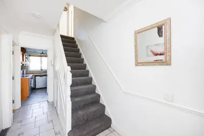 a staircase in a house with a picture on the wall at 6 Bedroom Larger group House with Parking Corringham Stanford Le Hope in Horndon on the Hill
