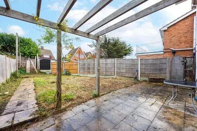 an empty backyard with a fence and a bench at 6 Bedroom Larger group House with Parking Corringham Stanford Le Hope in Horndon on the Hill