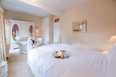 a bedroom with a white bed with a book on it at 4 Ropers Court, Lavenham in Lavenham