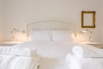 a white bed with white sheets and pillows at 4 Ropers Court, Lavenham in Lavenham