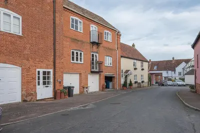 an empty street in a town with brick buildings at 4 Ropers Court, Lavenham in Lavenham