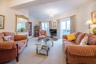 a living room with two couches and a table at 4 Ropers Court, Lavenham in Lavenham