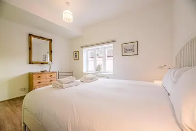 a bedroom with a large white bed and a window at 4 Ropers Court, Lavenham in Lavenham