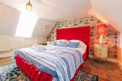 a bedroom with a red bed with a red headboard at Wellie Stern in Harwich