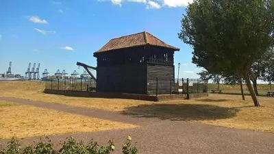 a small wooden building in a field with a tree at Wellie Stern in Harwich
