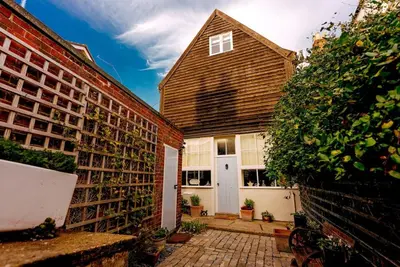 a house with a white door and a brick wall at Wellie Stern in Harwich