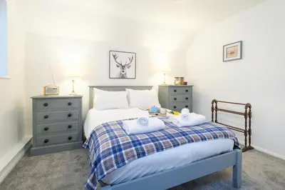 a bedroom with a bed with two towels on it at 1 King Street in Aldeburgh