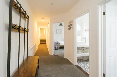 a hallway leading to a bathroom with a sink at 1 King Street in Aldeburgh