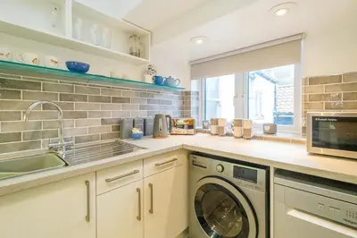 a kitchen with a washing machine and a sink at 1 King Street in Aldeburgh
