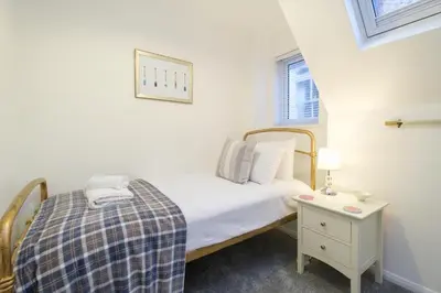 a small bedroom with a bed and a table at 1 King Street in Aldeburgh