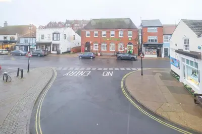 a city street with cars parked in a parking lot at 1 King Street in Aldeburgh