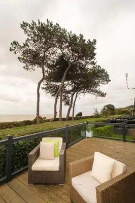 two chairs and a table on a deck with trees at San Remo in Sizewell