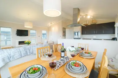 a dining room and living room with a table and chairs at San Remo in Sizewell