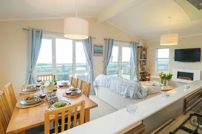 a dining room and living room with a table and chairs at San Remo in Sizewell