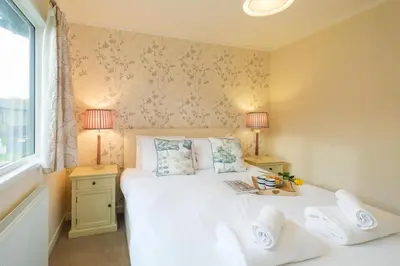 a bedroom with a bed with two lamps and a window at San Remo in Sizewell