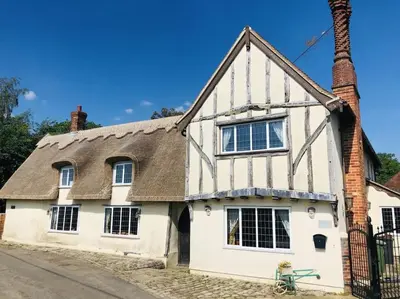 an old white house with a thatched roof at Beautiful thatched Dynes Cottage Finchingfield sleeps 10 in Finchingfield
