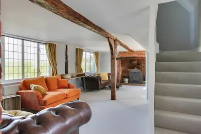 a living room with a couch and a fireplace at Beautiful thatched Dynes Cottage Finchingfield sleeps 10 in Finchingfield