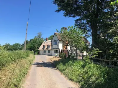 a house on the side of a dirt road at Beautiful thatched Dynes Cottage Finchingfield sleeps 10 in Finchingfield