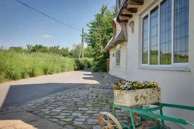a house with a flower pot on the side of it at Beautiful thatched Dynes Cottage Finchingfield sleeps 10 in Finchingfield