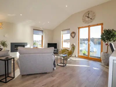 a living room with a couch and a clock on the wall at The Penthouse in Woodbridge