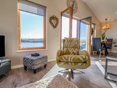 a living room with a chair and a table at The Penthouse in Woodbridge