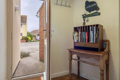 a door leading to a room with a book shelf at The Pines in Aldeburgh