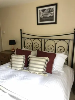 a bedroom with a white bed with red and white pillows at The Jolly Sailor, Orford in Orford