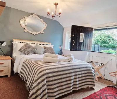 a bedroom with a bed with a mirror on the wall at The Jolly Sailor, Orford in Orford