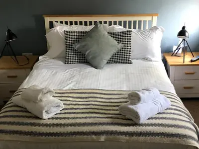 a bed with two towels on top of it at The Jolly Sailor, Orford in Orford