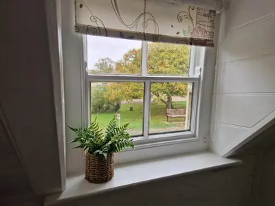 a window with a potted plant sitting on a window sill at The Jolly Sailor, Orford in Orford
