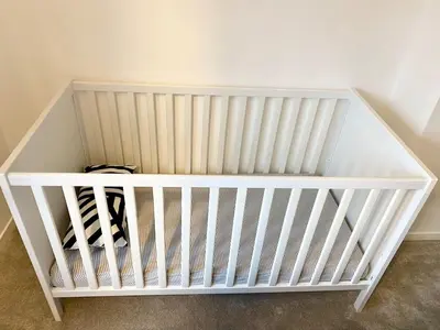 a white crib in a corner of a room at Rest on Super-King Bed under The Starry Night in Chesterton