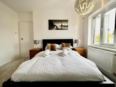 a large white bed in a bedroom with a chandelier at Rest on Super-King Bed under The Starry Night in Chesterton