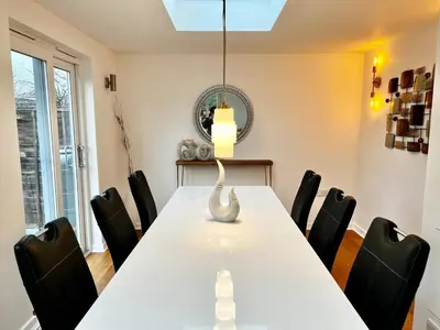 a dining room with a white table and black chairs at Rest on Super-King Bed under The Starry Night in Chesterton