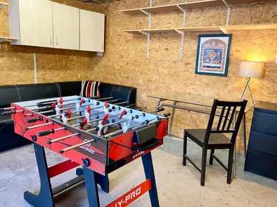 a ping pong table in a living room with a chair at Rest on Super-King Bed under The Starry Night in Chesterton