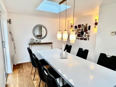 a dining room with a white table and black chairs at Rest on Super-King Bed under The Starry Night in Chesterton