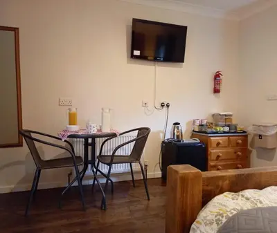a room with a table and two chairs and a bed at Donkey & buskins in Layer de la Haye