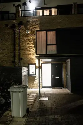 a brick building with a door and a trash can at Exquisite cozy house, close to Train Station and amenities in Harold Wood