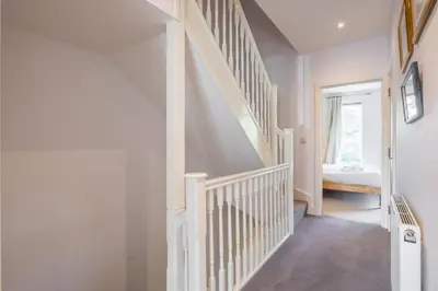 a white staircase in a home with a window at Charming & Spacious House With FREE PARKING in Chesterton