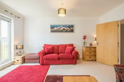 a red couch in a living room with a red rug at Charming & Spacious House With FREE PARKING in Chesterton