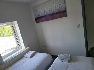 a room with two beds next to a window at Vetrelax Southend Suites- Sleeps up to 5 - Free Wi-Fi - Contractors - Families- Free Parking- Long Term Stays in Southend-on-Sea