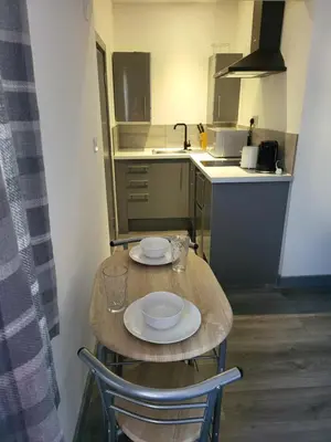a small kitchen with a table with two plates on it at Vetrelax Southend Suites- Sleeps up to 5 - Free Wi-Fi - Contractors - Families- Free Parking- Long Term Stays in Southend-on-Sea