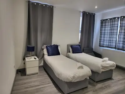 a room with two beds with blue pillows at Vetrelax Southend Suites- Sleeps up to 5 - Free Wi-Fi - Contractors - Families- Free Parking- Long Term Stays in Southend-on-Sea