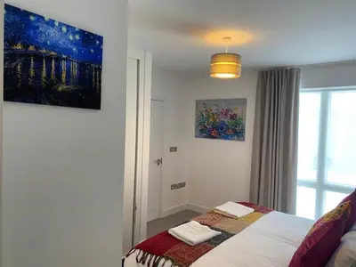 a bedroom with a bed with two towels on it at Exquisite & Contemporary 2 Bed Apartment w Parking 10 mins walk to Papworth, Addenbrookes hospitals & Bio Medical Campus in Trumpington