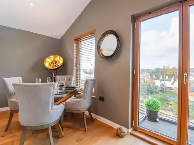 a dining room with a table and chairs and a window at Woodbridge Penthouse in Woodbridge