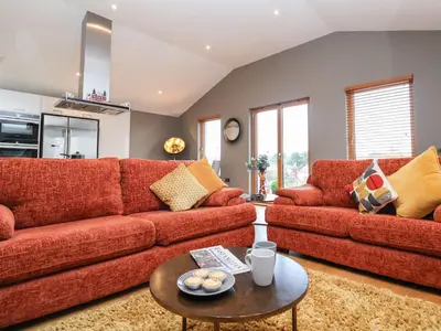 a living room with two red couches and a table at Woodbridge Penthouse in Woodbridge